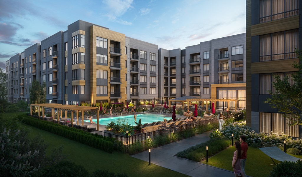 A modern apartment complex with a pool and landscaping.