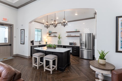 a kitchen with a center island and a stainless steel refrigerator