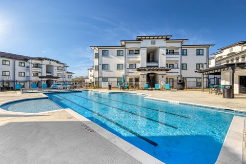 a large swimming pool with apartments in the background