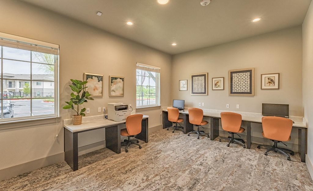 an office with desks and chairs and a window