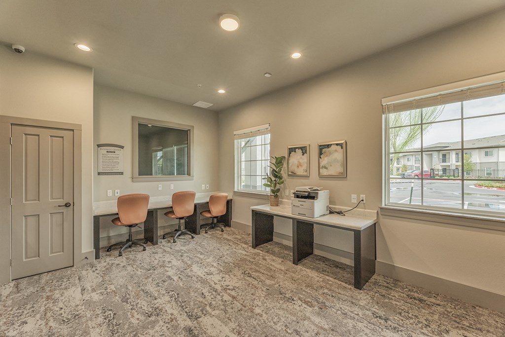 an office with a desk and chairs and a window