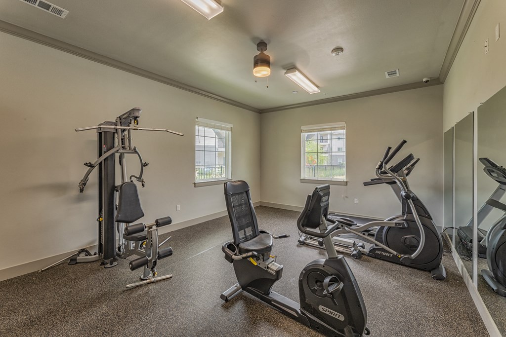 a gym with exercise equipment and mirrors on the wall