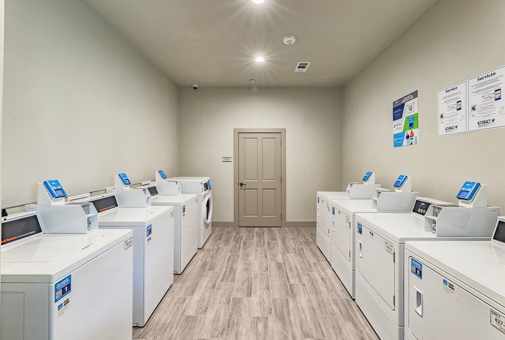 a room full of washers and dryers in a laundromat