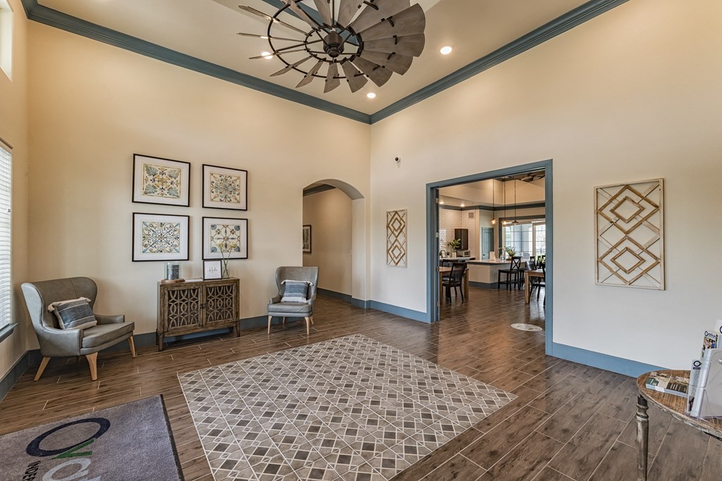 a living room with chairs and a chandelier