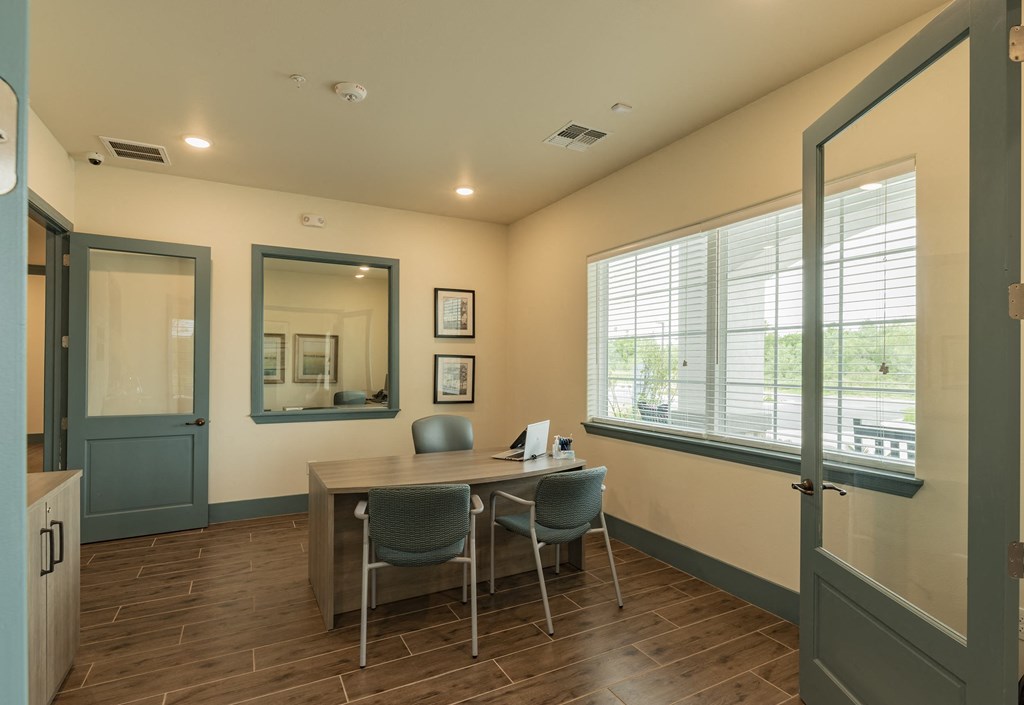 a conference room with a table and chairs and a window