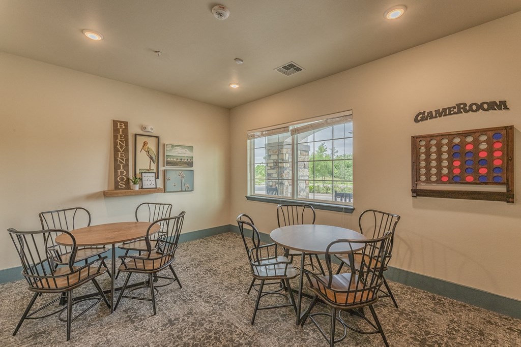 a community room with tables and chairs and a bulletin board