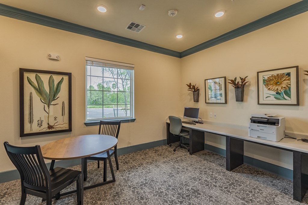 a home office with two desks and a printer and a table