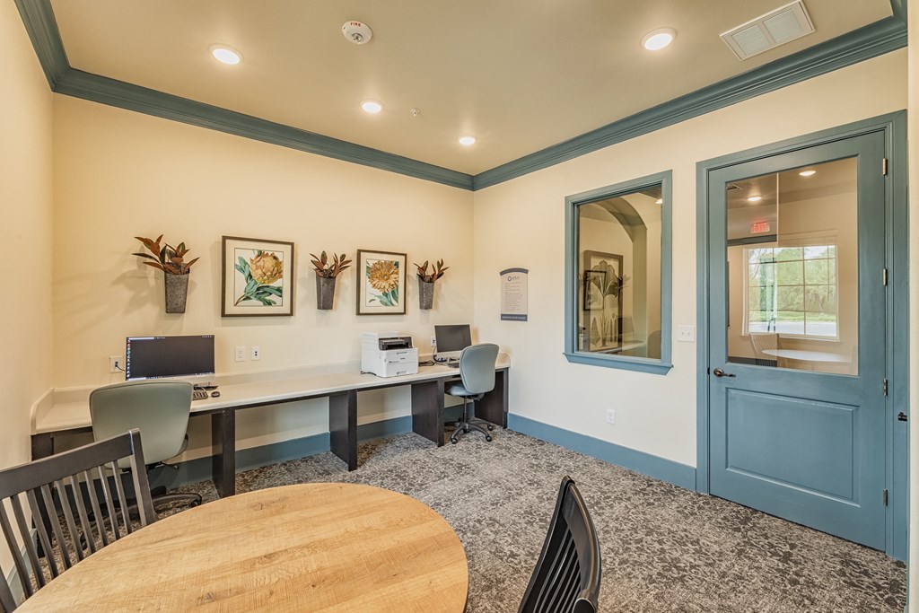 a conference room with a round table and chairs and a blue door