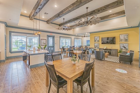 a dining room with tables and chairs and a kitchen