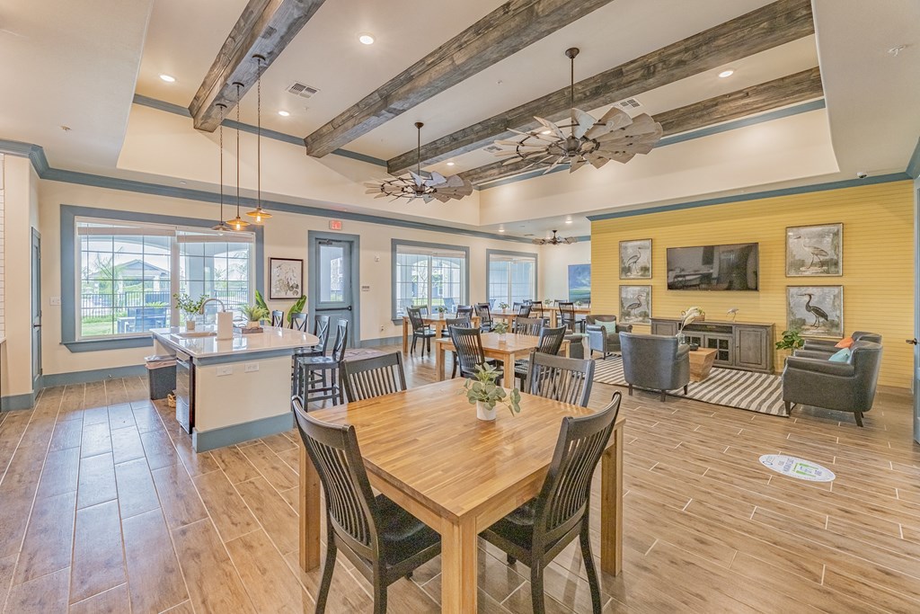a dining room with tables and chairs and a kitchen
