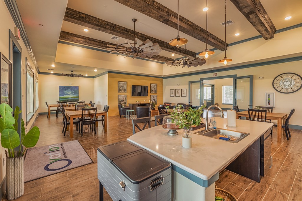 a kitchen with a island and a dining room with tables and chairs