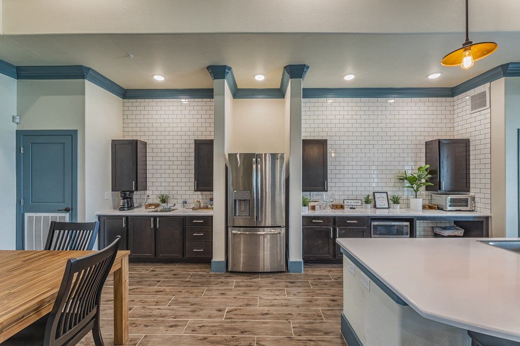 an open kitchen and dining room with stainless steel appliances and a wooden table