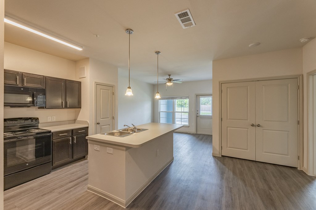 an empty kitchen with an island and stainless steel appliances