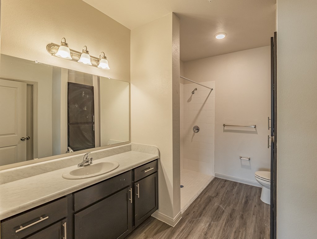 a bathroom with a large mirror and a toilet and a shower