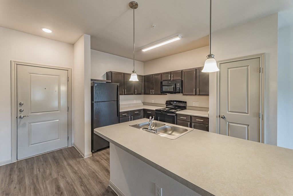 an empty kitchen with a sink and a refrigerator