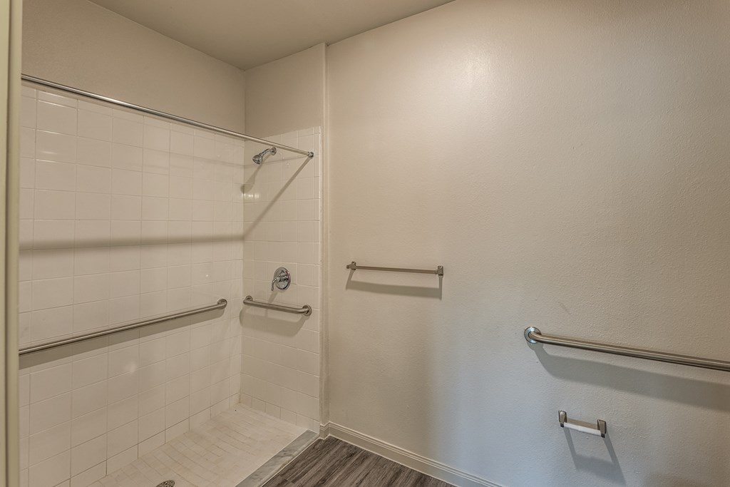 a white bathroom with a shower and towel racks