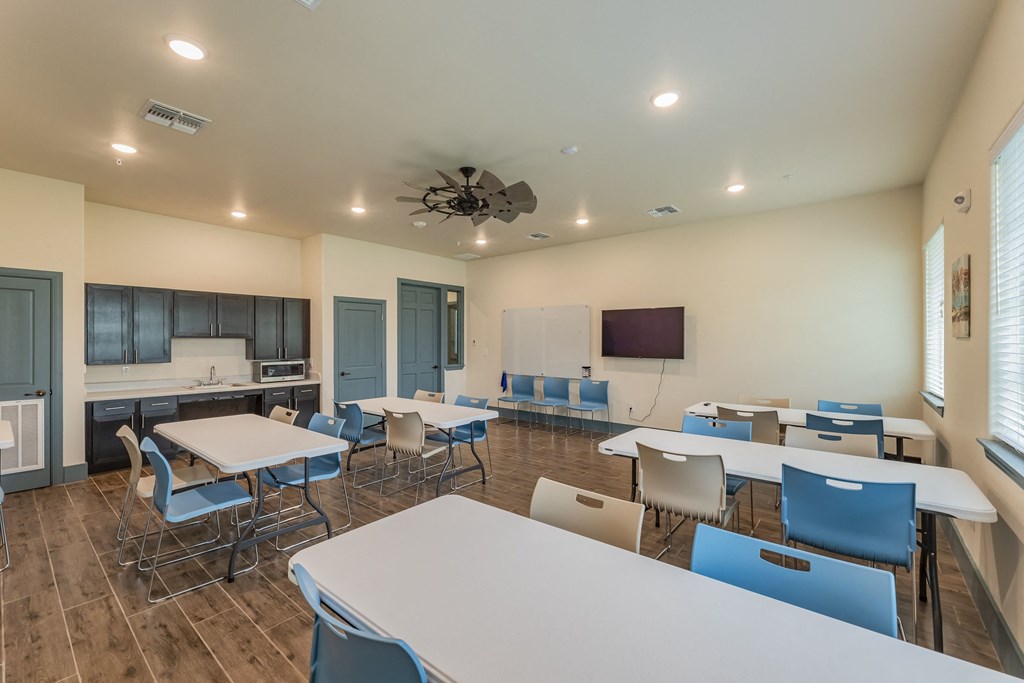 a dining room with tables and chairs and a kitchen