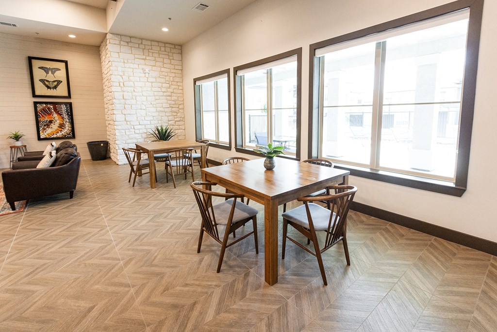 a dining room with a wooden table and chairs and a large window