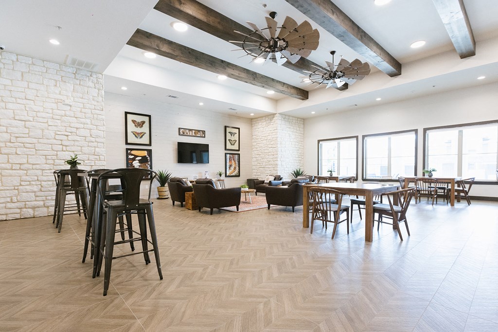 a living room with tables and chairs and a ceiling fan