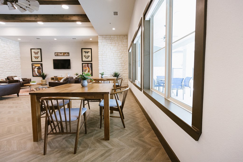a dining room with a wooden table and chairs and a large window