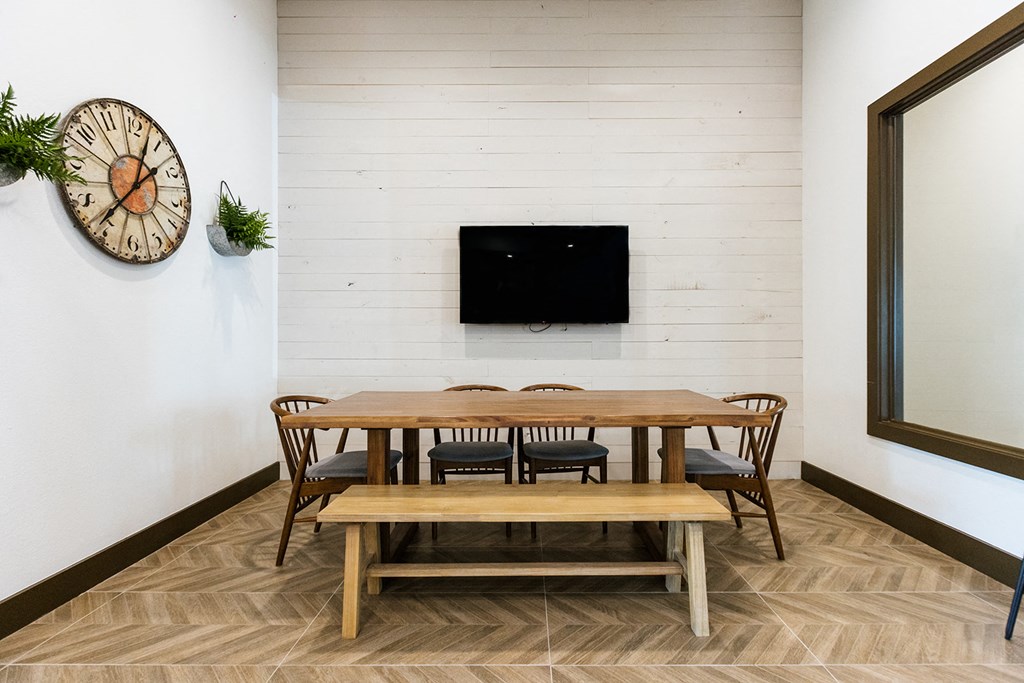 a dining room with a table and chairs and a wall mounted tv
