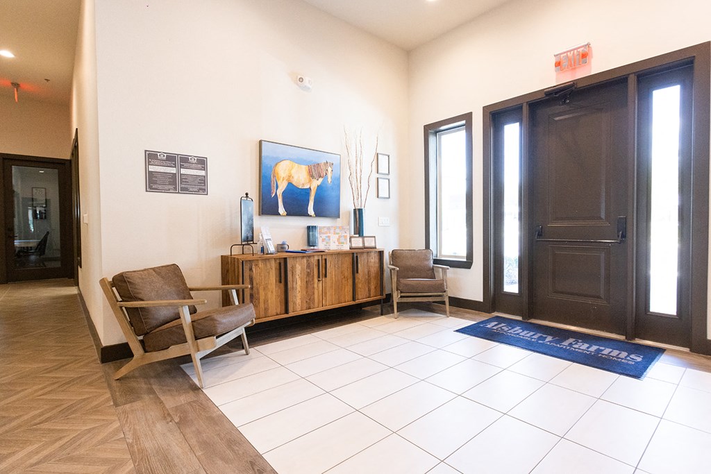 a lobby with two chairs and a cabinet with a painting of a horse