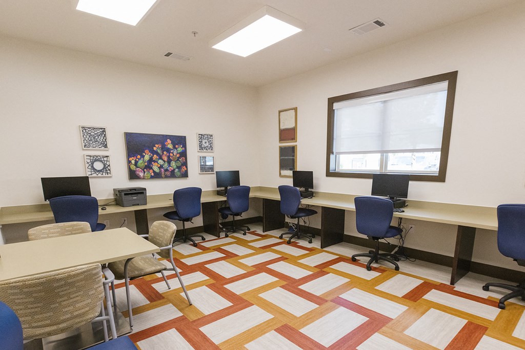 a study room with desks and chairs and a window