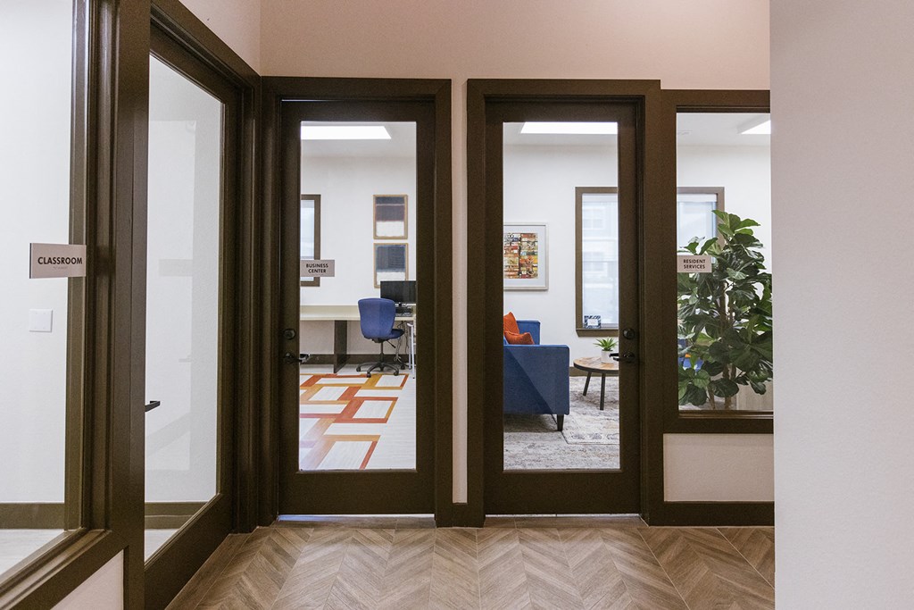a living room with sliding glass doors and a table with a blue chair