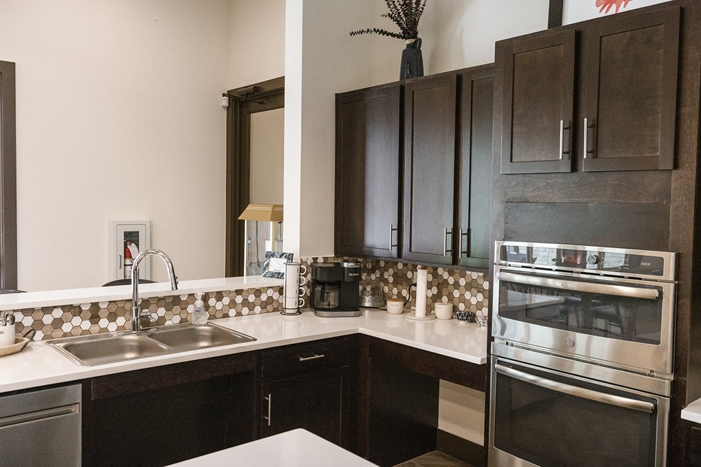 a kitchen with stainless steel appliances and black cabinets