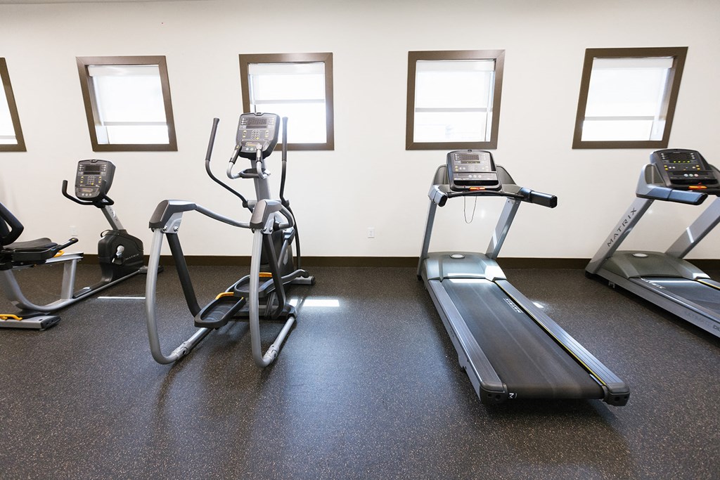 a gym with several pieces of exercise equipment on the floor