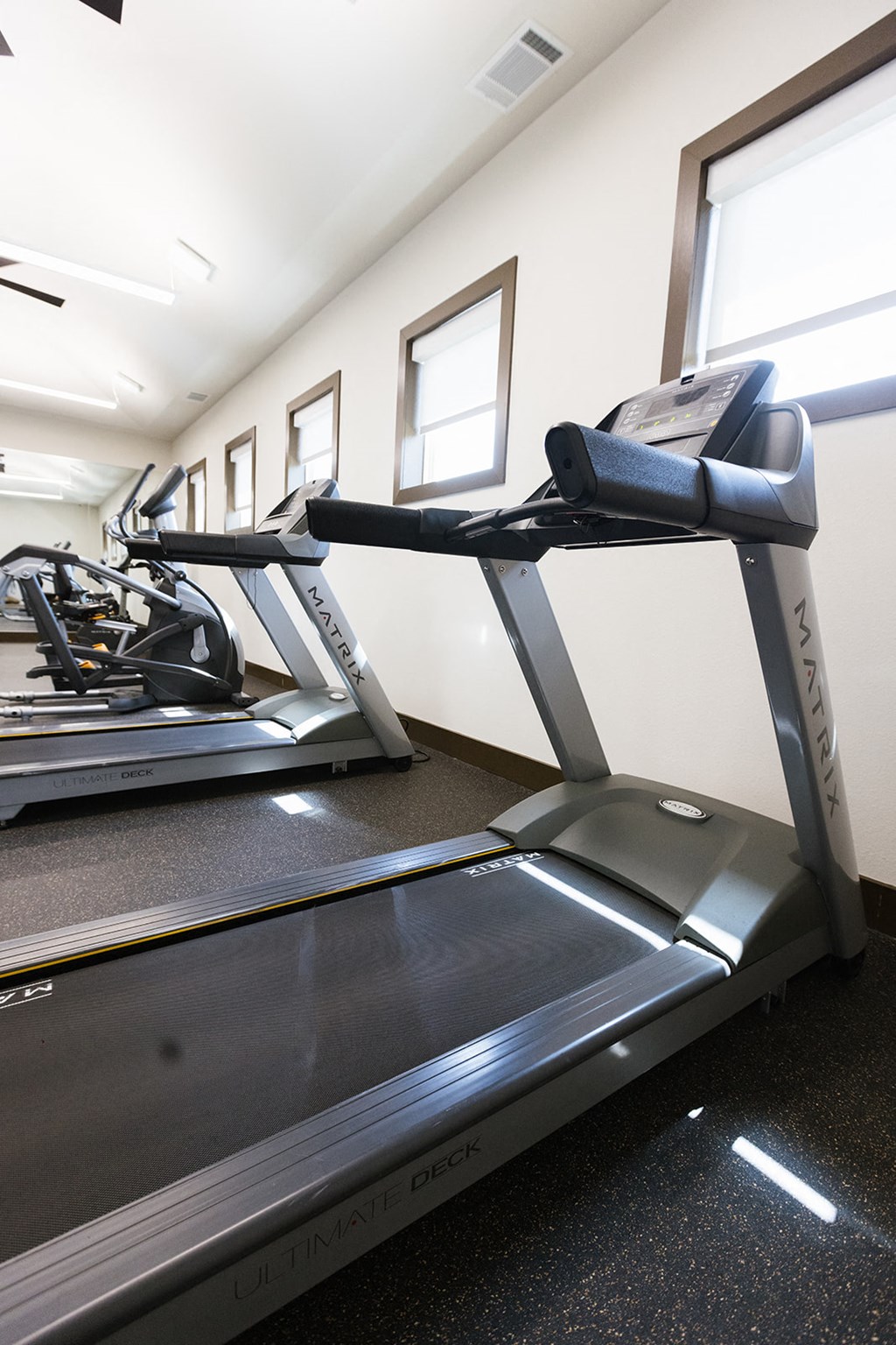 a gym with treadmills and other exercise equipment in a room