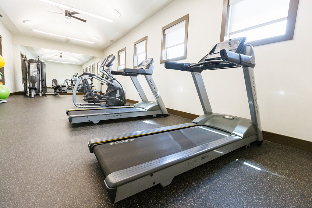 two treadmills and other exercise equipment in the gym of a building