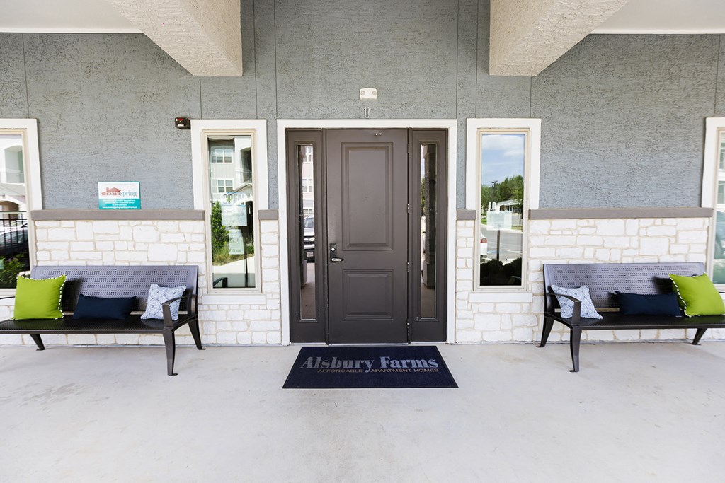 a front porch of a building with two benches and a door