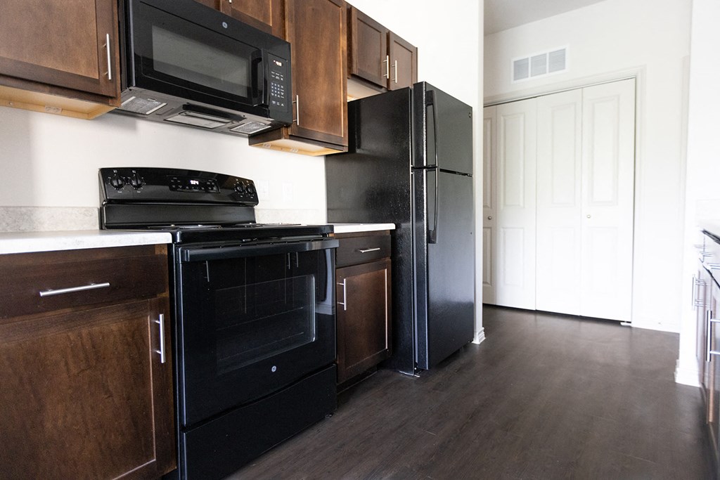a kitchen with black appliances and wooden cabinets and a black refrigerator