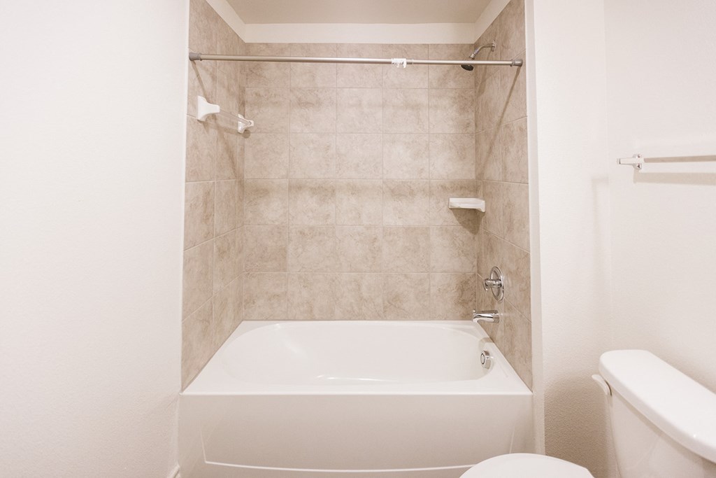 a white bathroom with a tub and a toilet