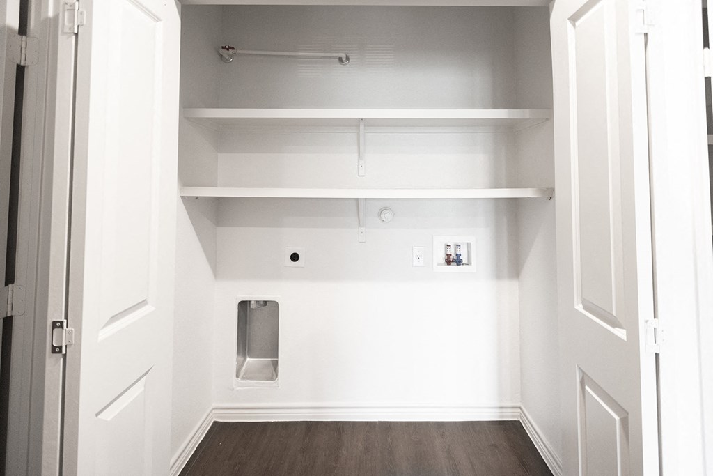 a room with white walls and white shelves and a urinal