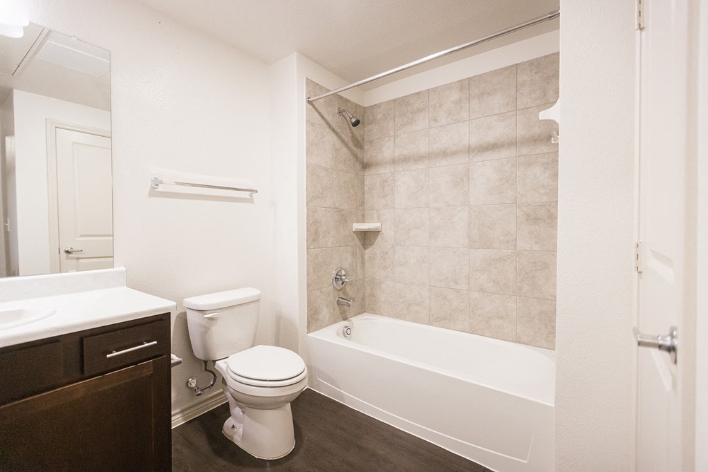 a bathroom with a toilet and a tub and a sink