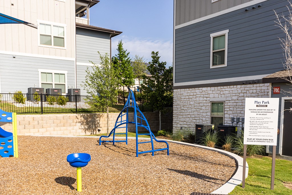 a blue swing set in a playground at an apartment complex