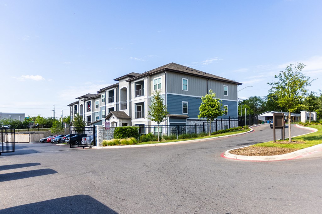 an empty street with an apartment building in the background