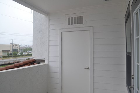 a white door on a white house with a balcony