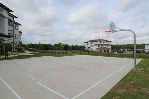 an outdoor basketball court in a neighborhood with houses