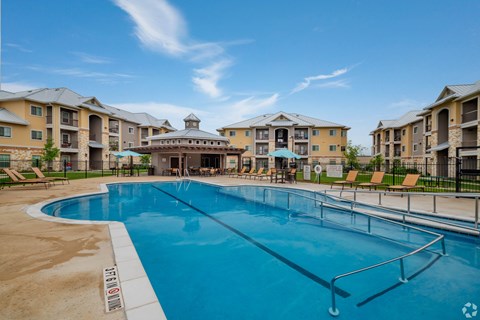 A large swimming pool in front of apartment buildings.