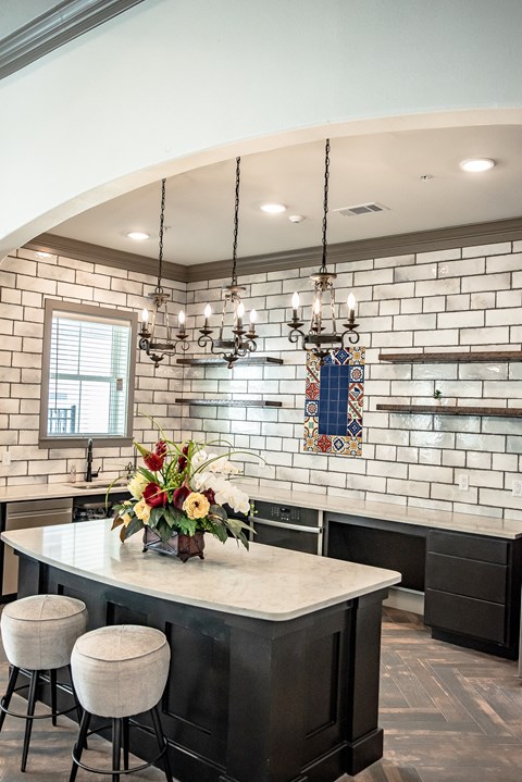 a kitchen with a marble counter top and white brick walls