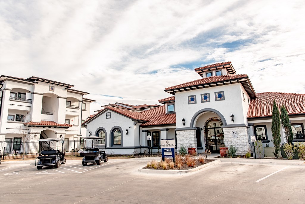 a building with a parking lot and two cars in front of it