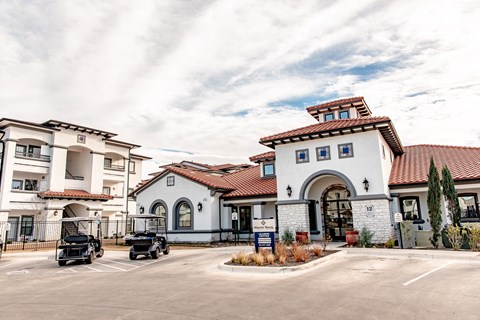 a building with a parking lot and two cars in front of it