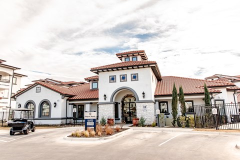 the front of a building with a parking lot and a golf cart