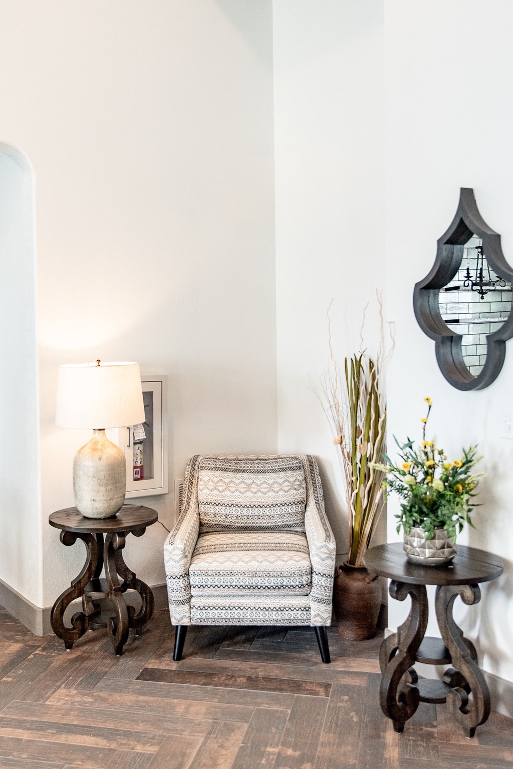 a living room with a chair and two tables