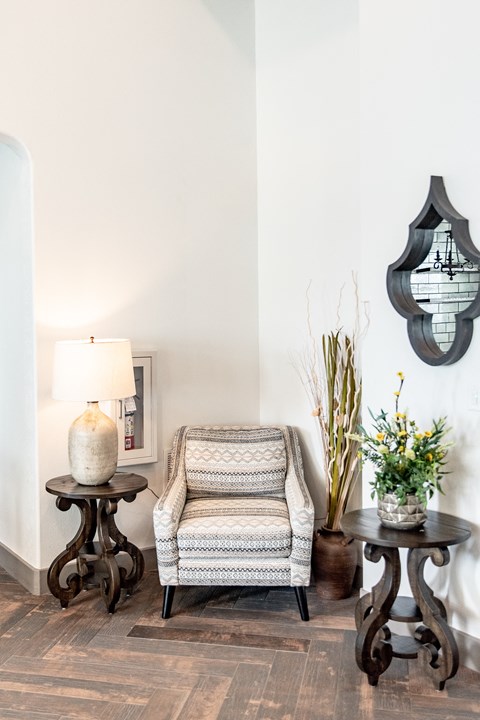 a living room with a chair and two tables