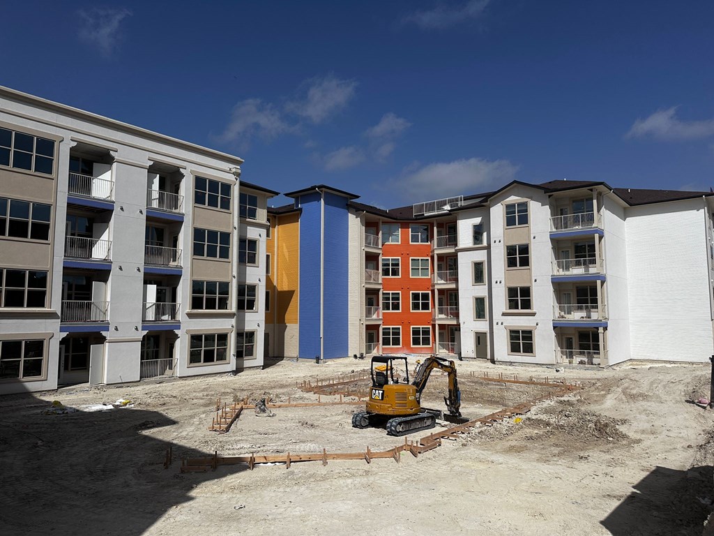 a bulldozer sits in the middle of a construction site next to an apartment building