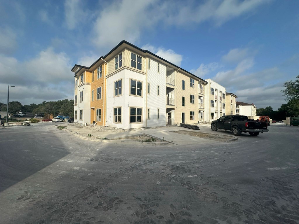 an apartment building with a car parked in a parking lot